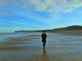 Rear view of man standing on beach