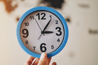 Close-up of hand holding clock