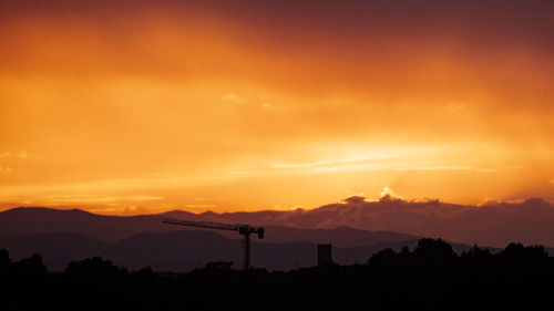 Scenic view of silhouette mountains against orange sky