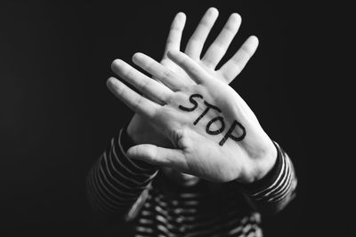 Close-up of human hand against black background