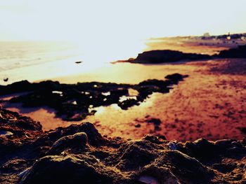 Close-up of sea against clear sky at sunset