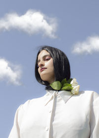 Portrait of a beautiful young woman against sky