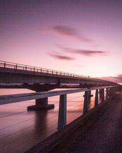 Bridge over sea against sky during sunset