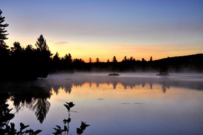 Scenic view of lake against clear sky during sunset