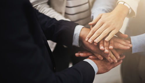 Midsection of business people stacking hands