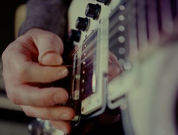 Midsection of man playing guitar