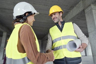 Architects shaking hands with each other at construction site