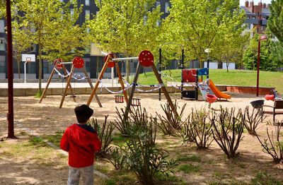 Rear view of boy playing on playground