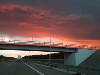 Bridge over road against sky during sunset