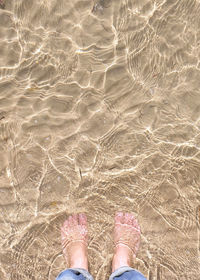 Low section of woman standing in water