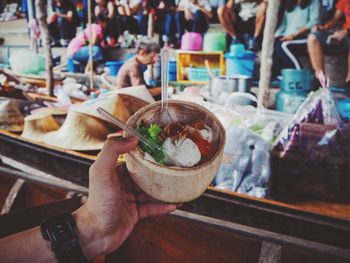 Cropped hand holding ice cream on nutshell bowl