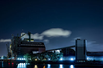 Low angle view of illuminated buildings against sky at night