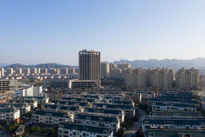 Aerial view of buildings in city against clear sky