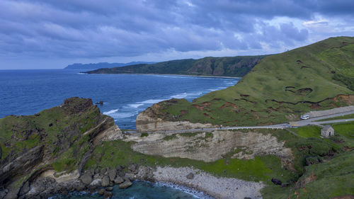 Scenic view of sea and mountains against sky