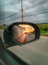 Car on street against sky during sunset