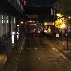 Road passing through illuminated city at night