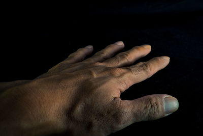 Close-up of hands against black background