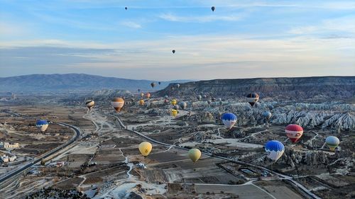 Birds flying over landscape against sky