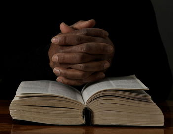 Black man praying to god on gray background with people stock image stock photo