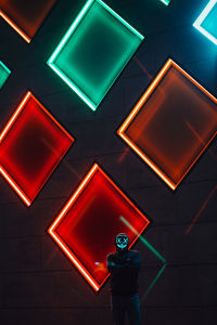 Low angle view of a man standing on illuminated ceiling