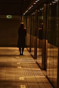 Rear view of person standing on railroad station platform