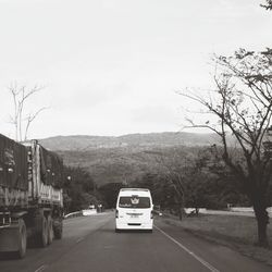 Car on road by mountain against sky