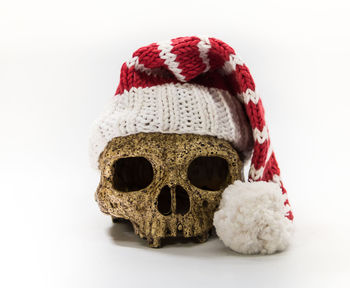 Close-up of person wearing hat against white background