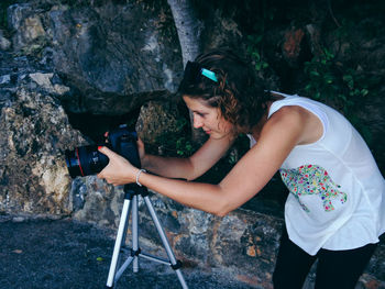 High angle view of young woman photographing through camera