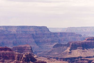 Scenic view of rock formations against cloudy sky