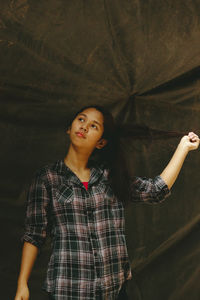 Young woman standing against black background