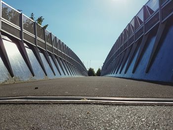 Road by bridge in city against sky