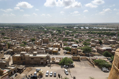 High angle view of town by sea against sky