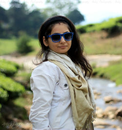 Portrait of young woman wearing sunglasses standing outdoors