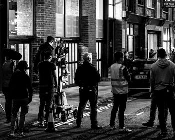 People standing on street against buildings in city