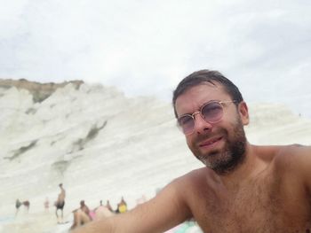 Portrait of shirtless young man on beach
