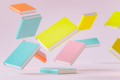 View of books floating against pink background