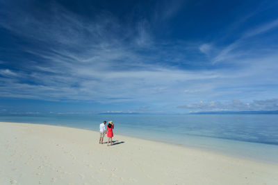 People on beach against sky