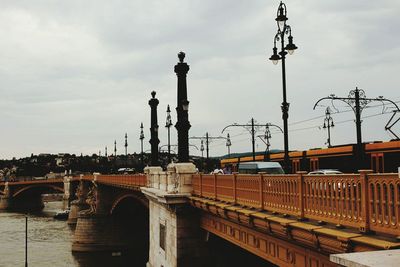 Train on bridge against sky in city