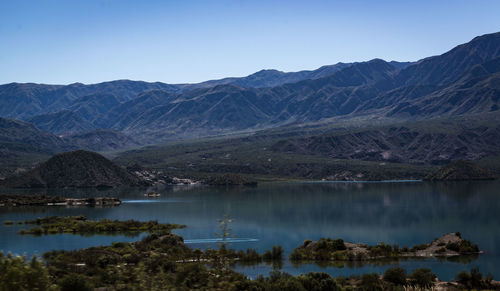 Scenic view of lake by mountains against sky