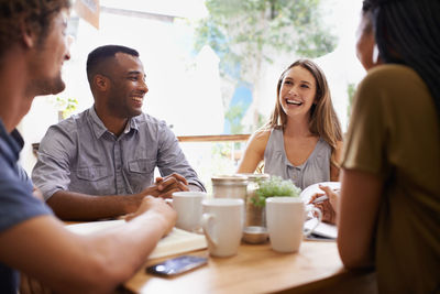 Happy business colleagues sitting in cafe