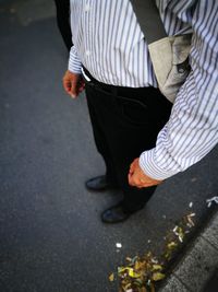 Low section of man standing on road