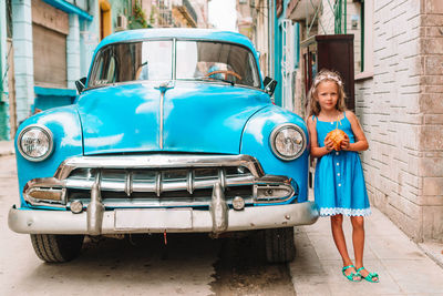 Portrait of smiling woman standing by car