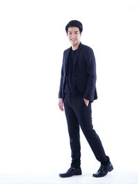 Portrait of young man standing against white background