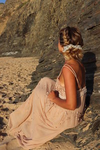 Rear view of woman sitting at beach