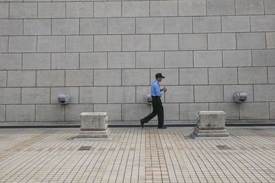 Side view of a man walking on footpath