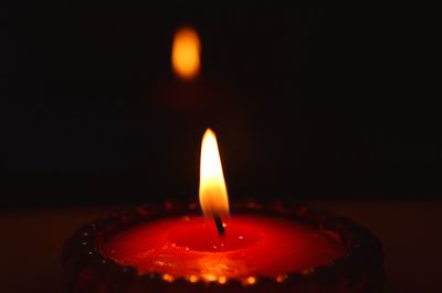 Close-up of tea light candle in darkroom