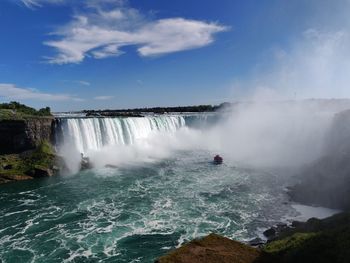 Scenic view of waterfall against sky