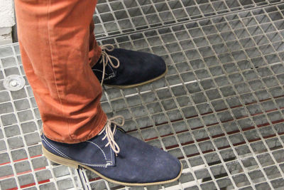 Low section of man standing on tiled floor