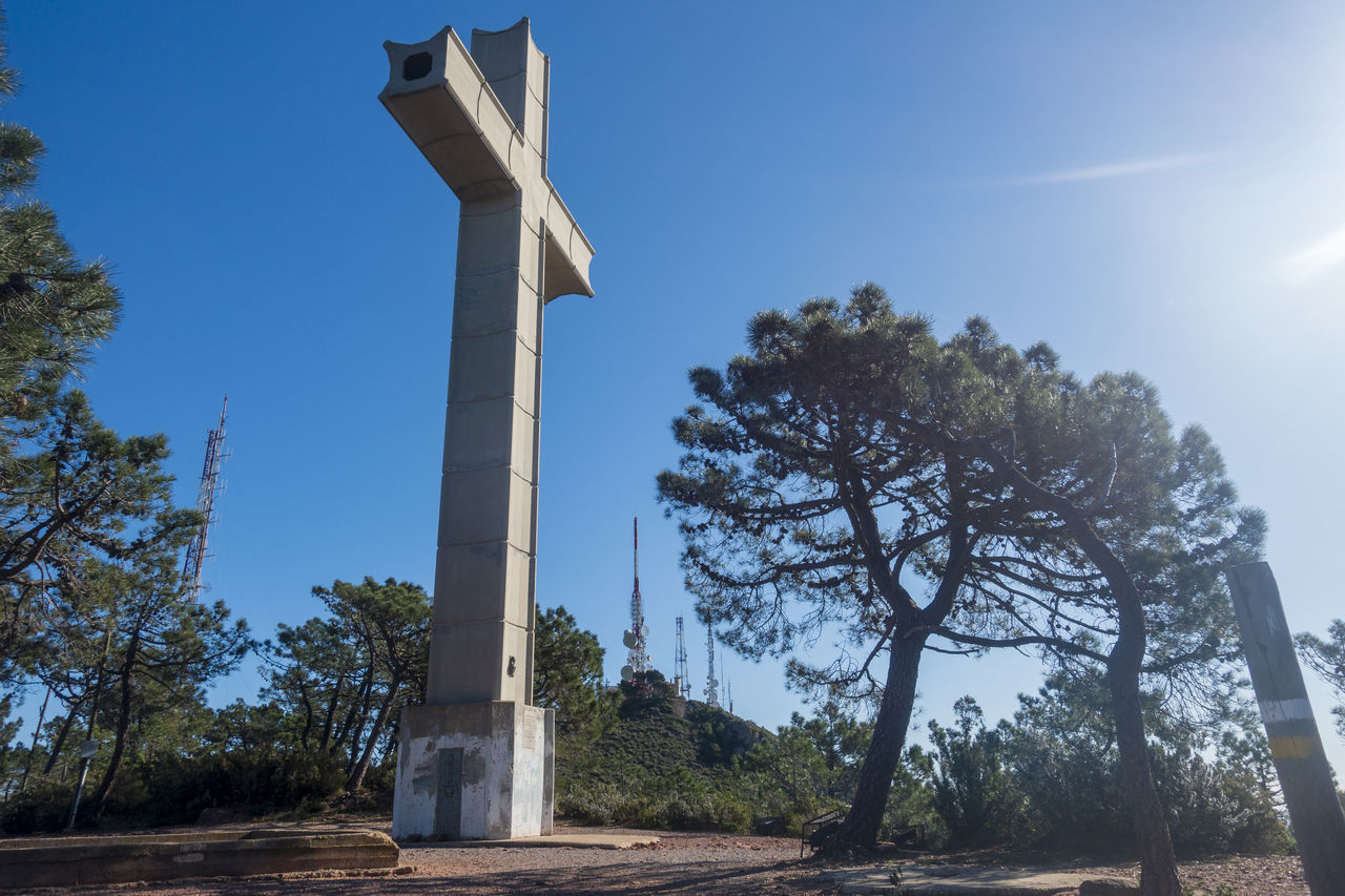 LOW ANGLE VIEW OF CROSS AGAINST TREES AGAINST SKY