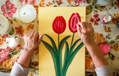 Midsection of woman holding flowers on table